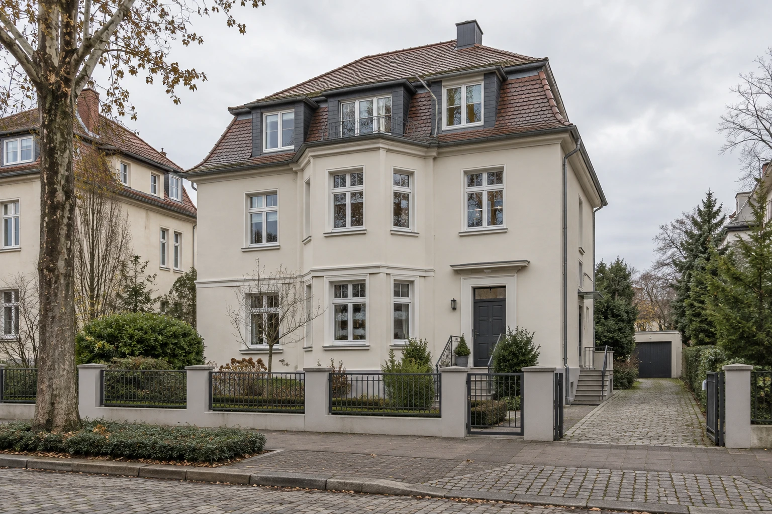 Saniertes Wohngebäude mit heller Fassade und modernen Fenstern